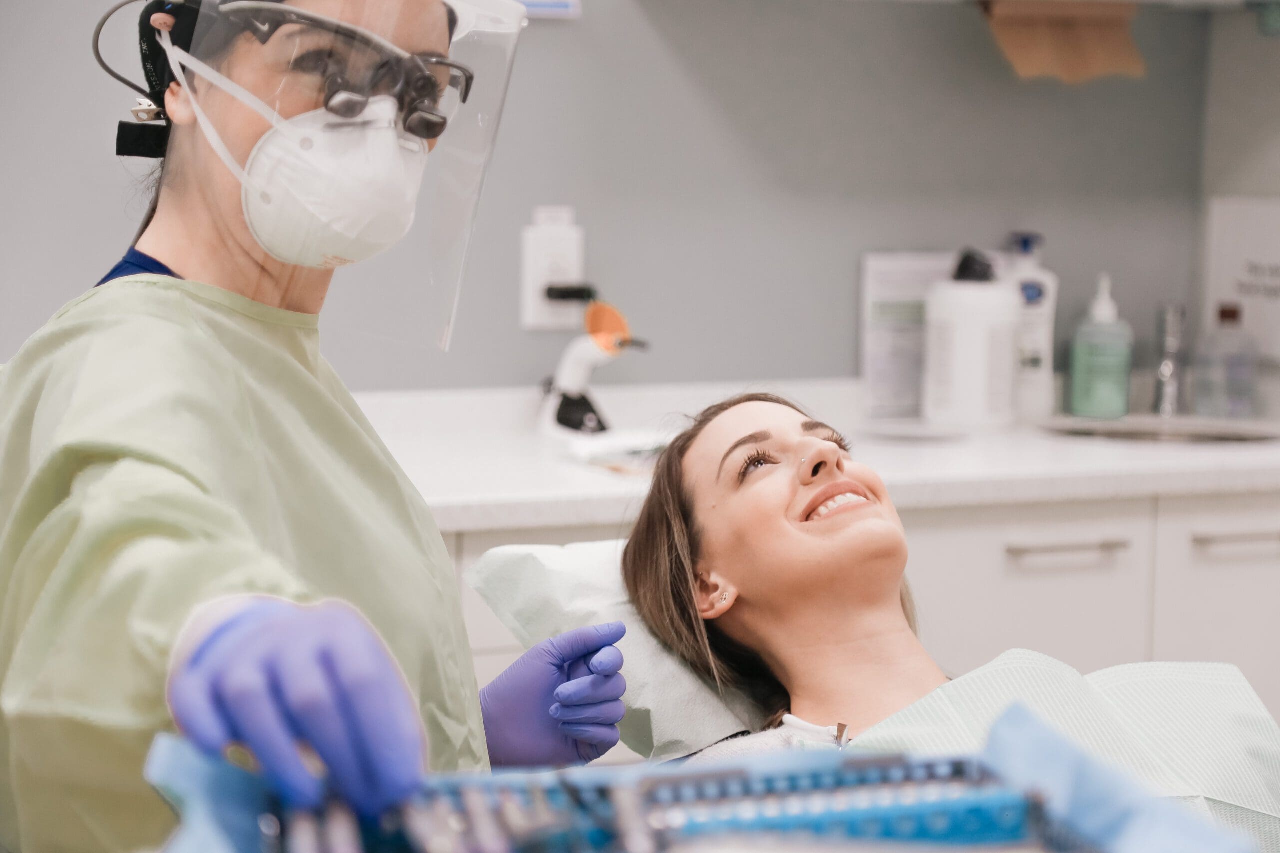 a hygienist about to clean a young womans teeth in a dental cleaning appointment